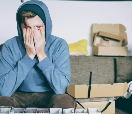직장 내 건강: 스트레스 관리의 필요성 man covering face with both hands while sitting on bench