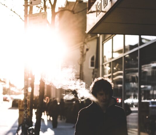 구취 예방과 치료: 입 냄새를 없애는 방법 man walking on sidewalk beside glass wall