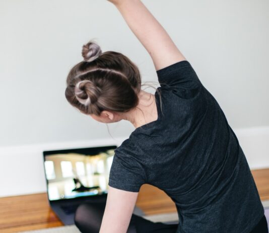 헬스장 vs 홈트: 어떤 운동이 더 효과적일까? woman in black t-shirt and black pants lying on black yoga mat