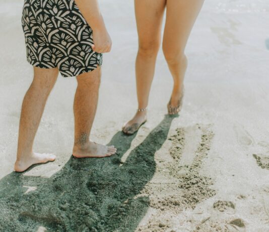 여름철 건강 지키는 실천법, 뜨거운 날씨에도 건강하게 보내는 방법 Two people walking on a sandy beach
