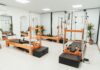 MZ세대와 시니어 모두 사로잡은 필라테스, 올해 건강 트렌드로 급부상 a gym with a row of machines and mirrors