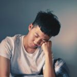 “만성피로, 시대의 질병에서 벗어나려면? 최신 트렌드가 제안하는 회복 솔루션” man resting his cheeks on hand