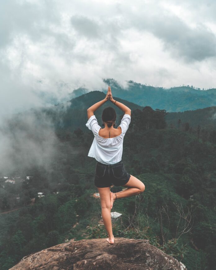 Photo by Yannic Läderach woman standing on rock facing forest