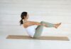 집과 일상 속 필라테스, 건강 트렌드로 자리잡다 Woman in boat pose on yoga mat
