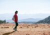 똑똑하게 걷기, 나를 가꾸는 가장 쉬운 건강 습관 a man with a backpack walking across a dry grass covered field